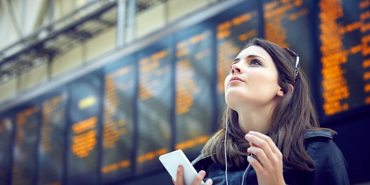 Employee looking at phone at a train station