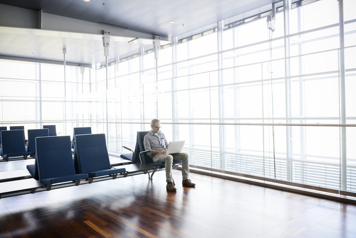 man on computer in airport