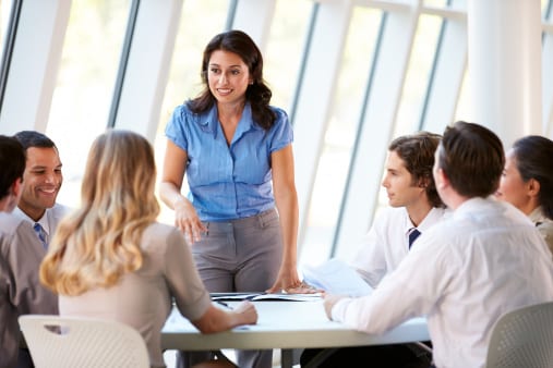 Lady in blue blouse standing up in boardroom 