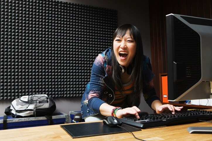 Lady standing behind desk with computer on it 