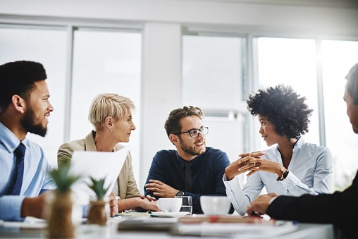Group of people sitting round a desk working together