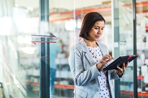 Lady in office standing up looking at tablet