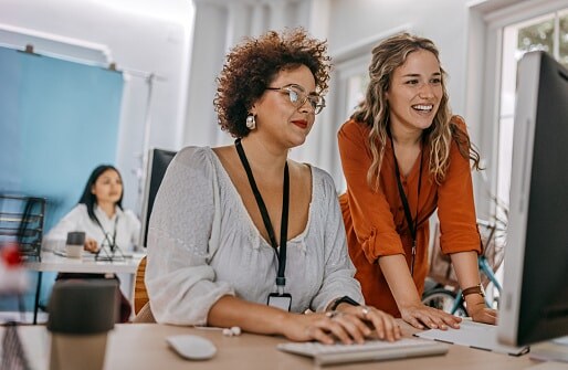 Two ladies looking at desk top computer