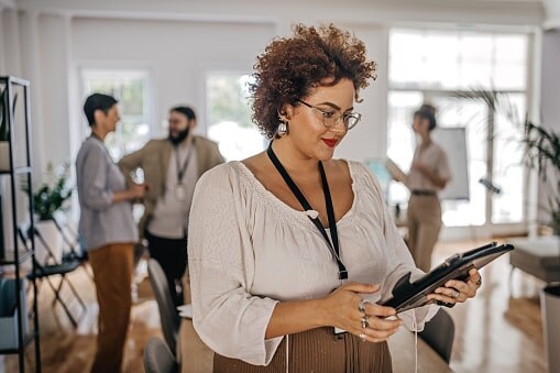 Lady in work environment looking a large tablet