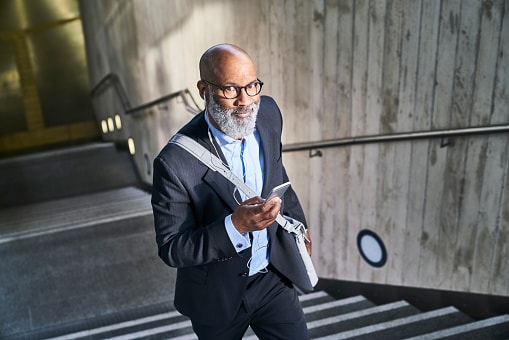 Man walking up the stairs holding his phone