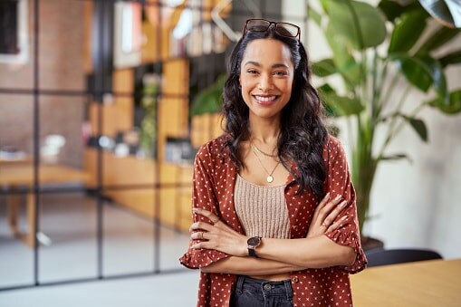 Lady in brown top standing in front of glass wall 