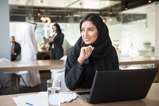 Lady in black sitting at desk with laptop open