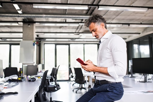 Man in office looking at phone