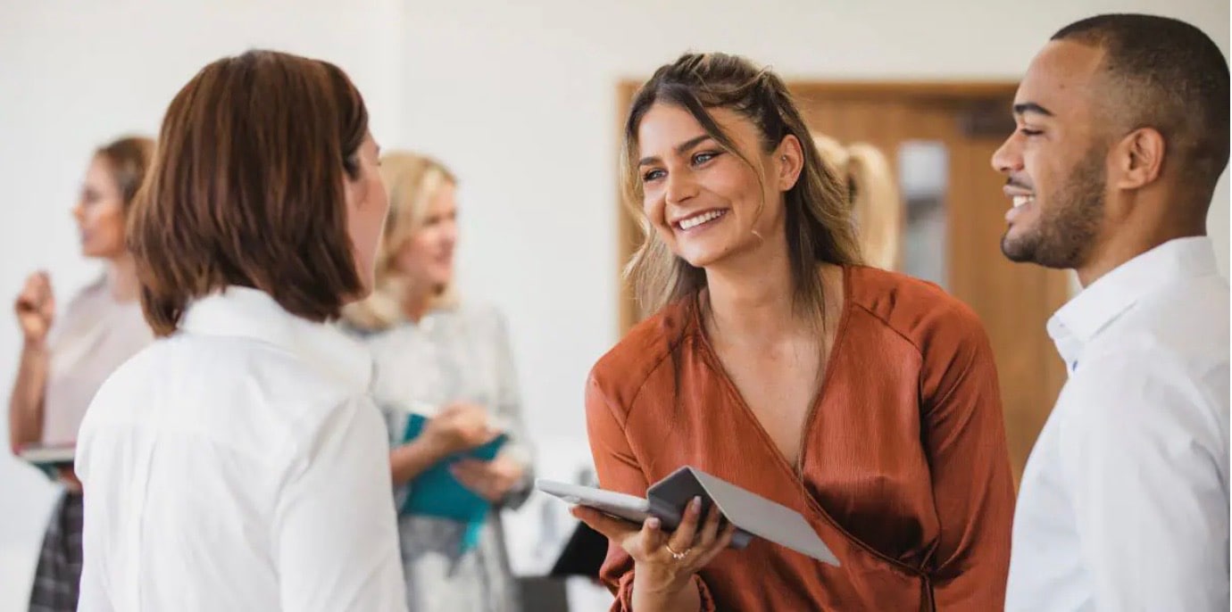 A group of employees smiling and looking happy